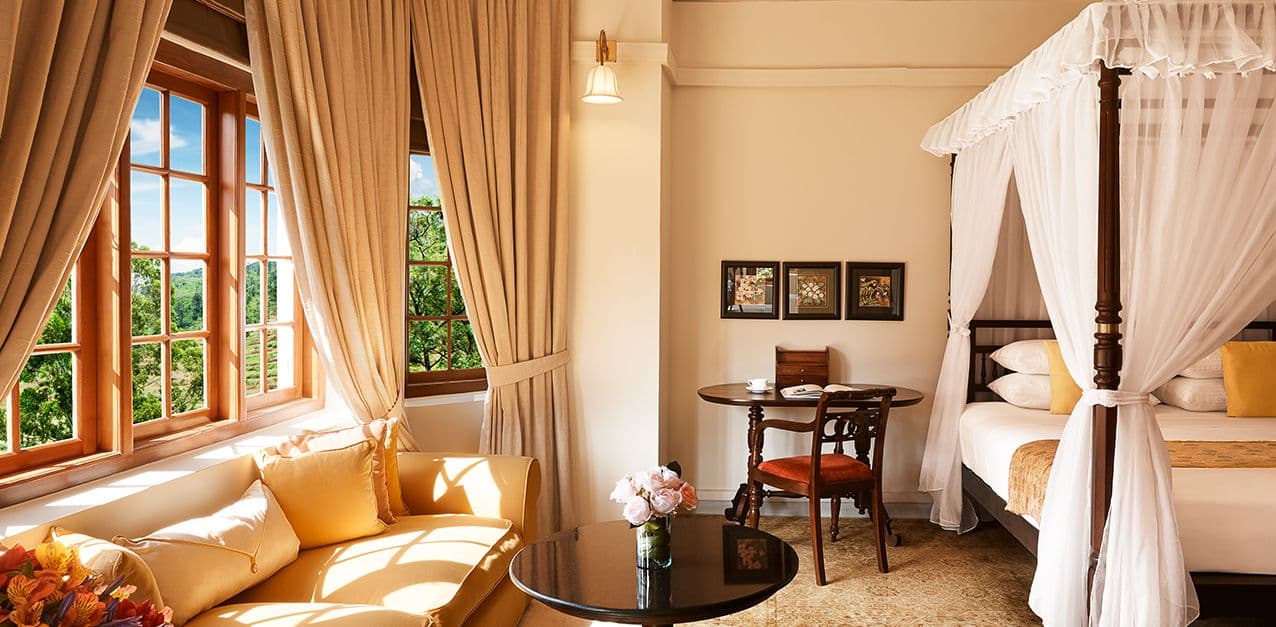 A bright, sunlit hotel room with mountain views